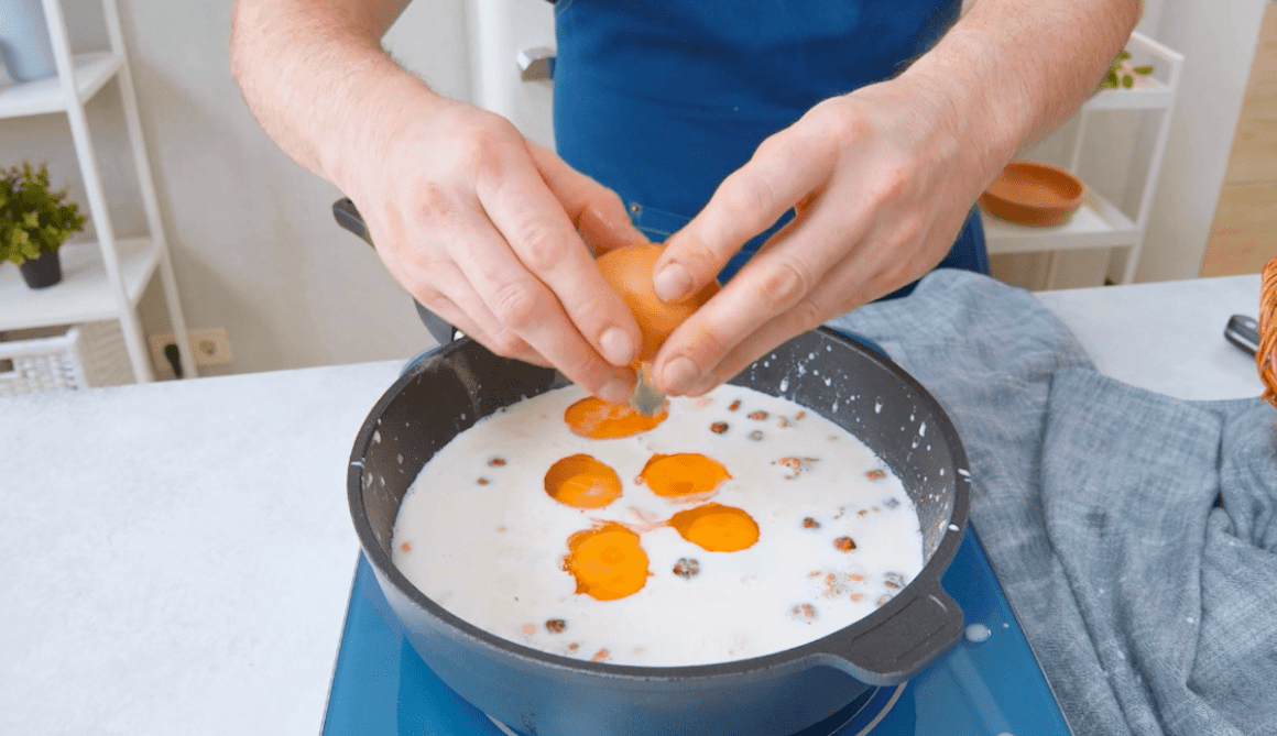 Eier werden in Milch in einer Pfanne geschlagen