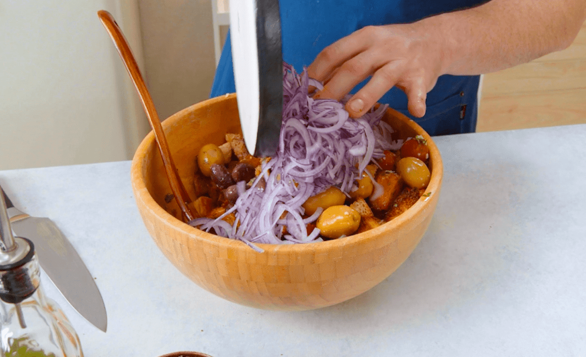 Zwiebel und gebackene Brotwürfel werden in eine Schüssel gegeben