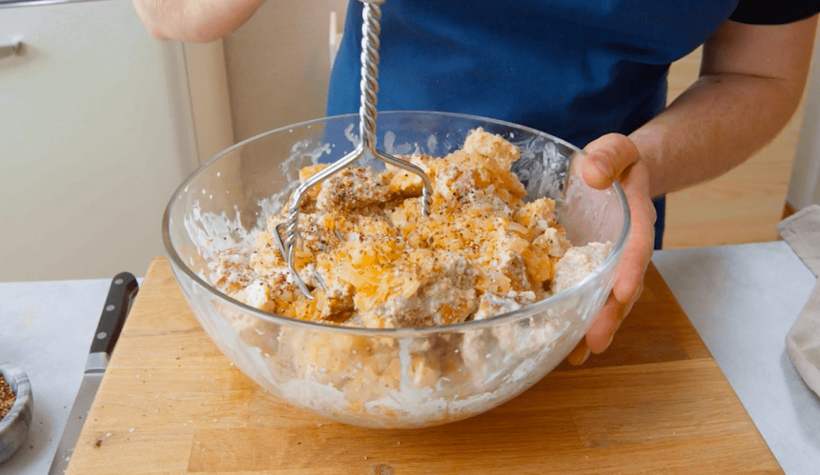 Eingeweichtes altes Brot wird mit einem Kartoffelstampfer zerstampft