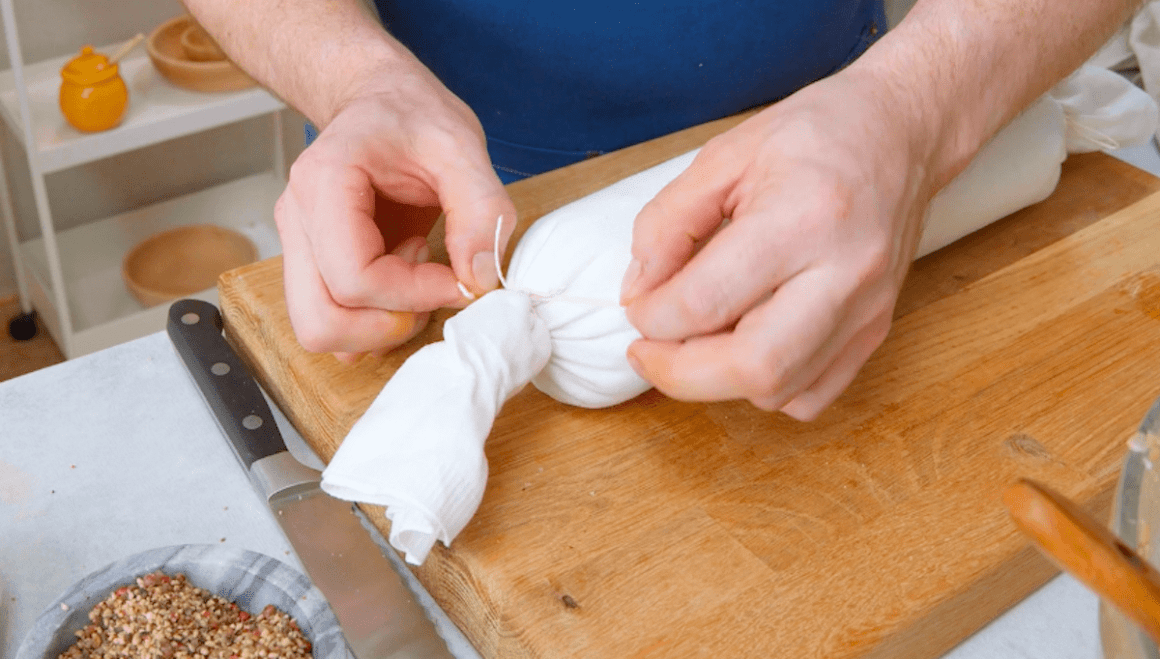 Ein Serviettenknödel wird mit Küchengarn zusammengebunden