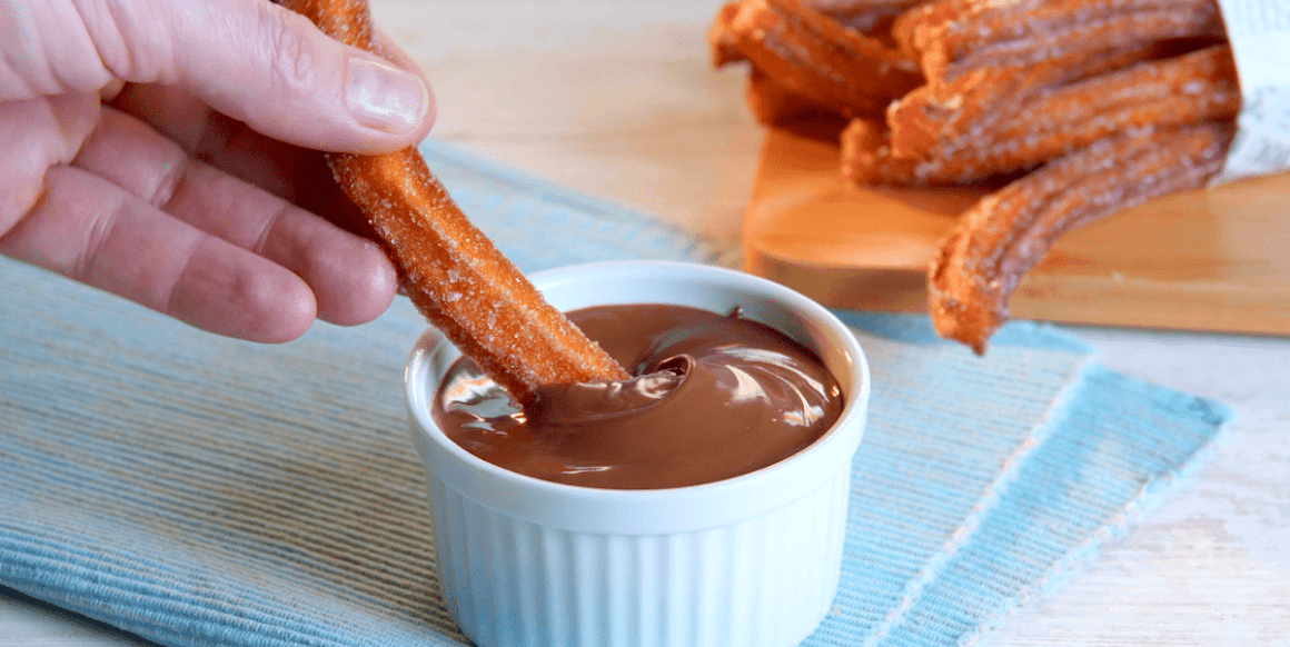 Süßkartoffel-Churros werden in Schokoladensauce gedippt.